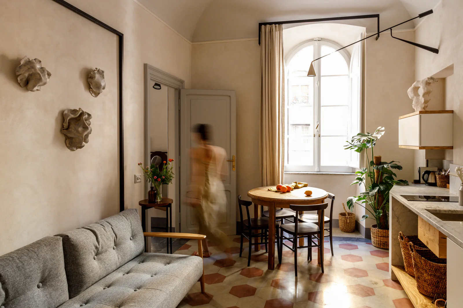 Elegant suite living room with a sofa, dining table and arched windows