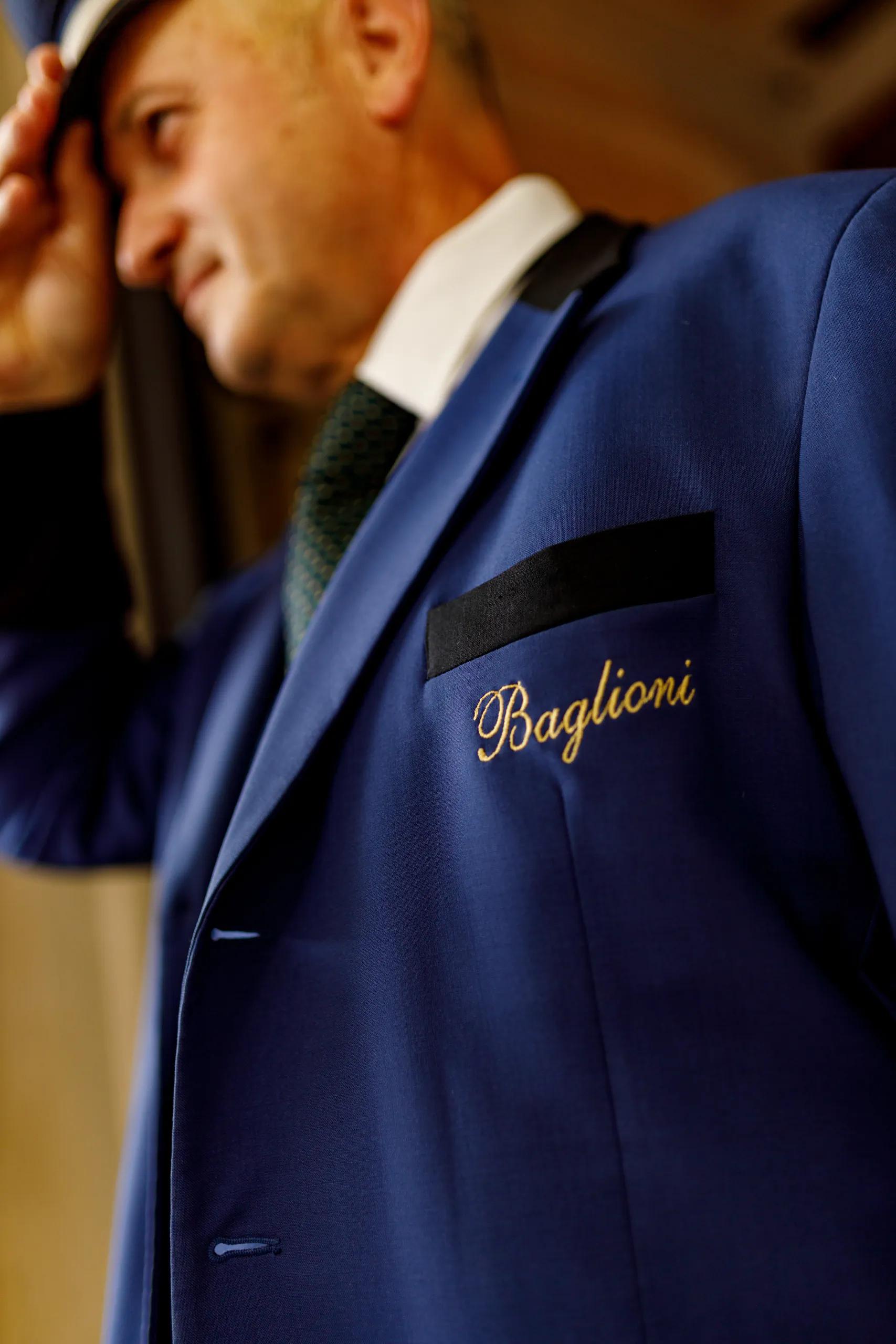 Doorman in a blue uniform embroidered 'Baglioni'