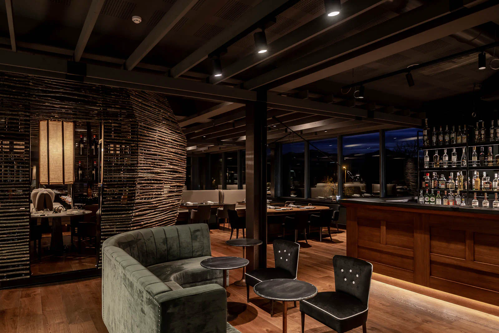 Lounge with a green velvet sofa and a bar counter behind