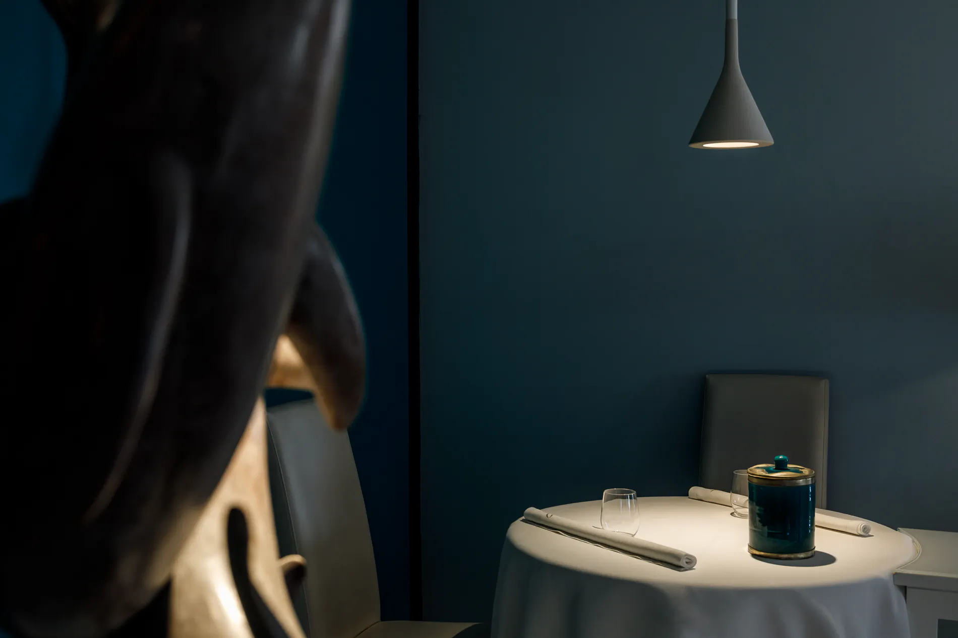 Moody hotel room corner with a pendant light and a side table